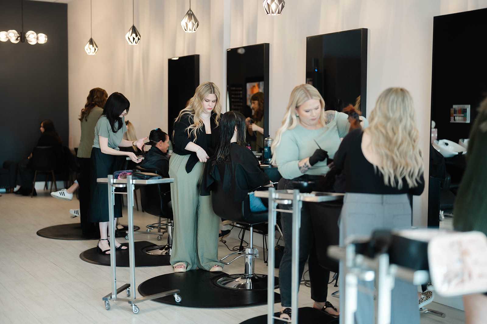Grey & Sage Salon stylists creating lived-in blonde hair color for clients in Wellington, Florida.