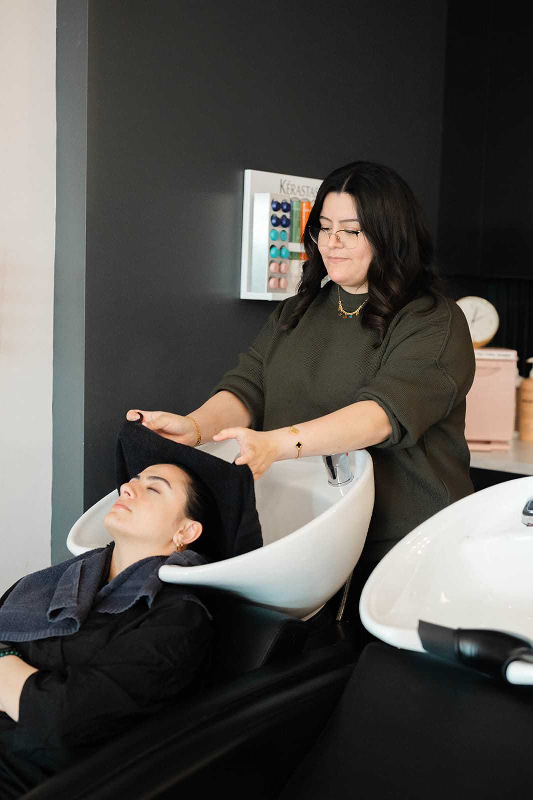 Woman getting hair washed at a salon with professional stylist.
