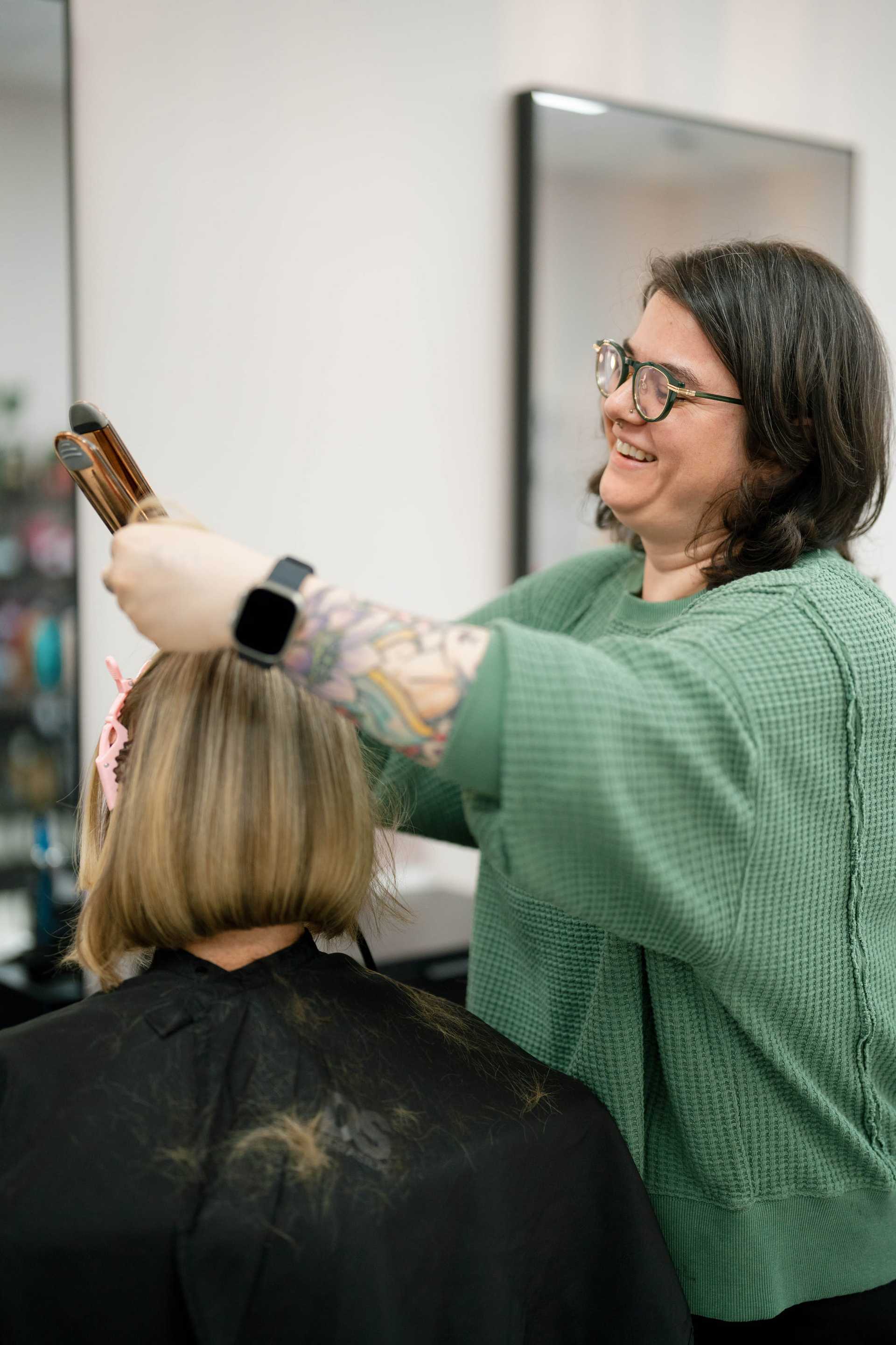 Stylist applying hair color to a client in a salon.